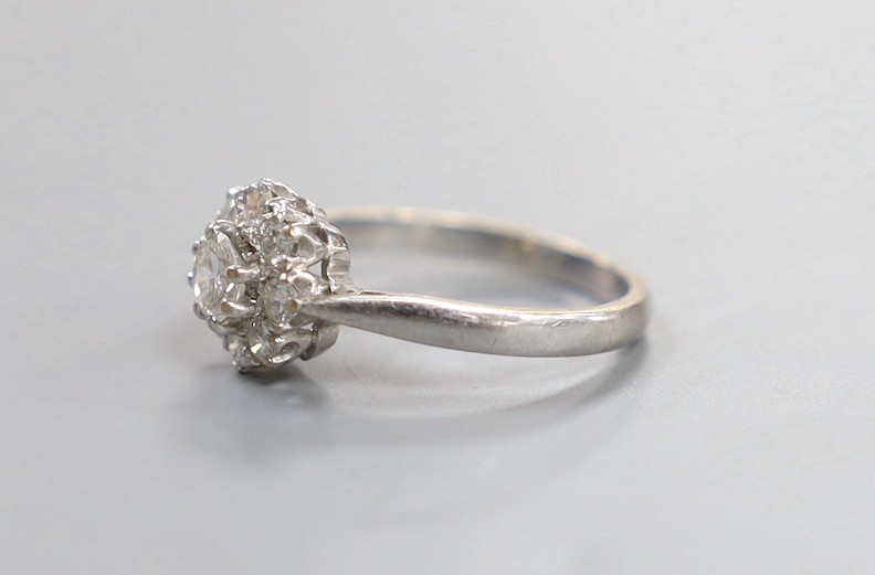 A modern 18ct white gold and nine stone diamond set flower head cluster ring